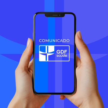 Mãos segurando um celular que contem os dizeres